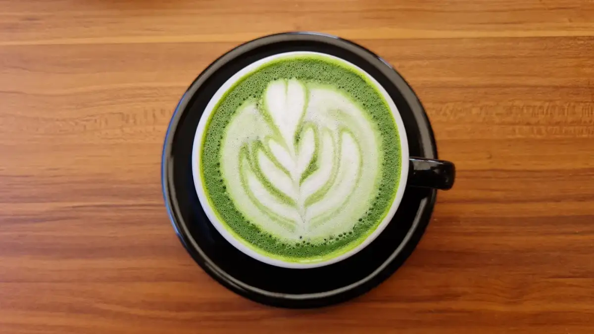 Matcha tea latte with rosetta latte art (illustrative photo)